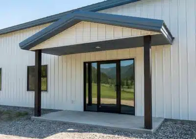 Covered lean-to porch on a steel pole barn in winter.