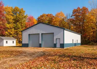 Detached two-car steel barn garage in Ontario surrounded by autumn trees