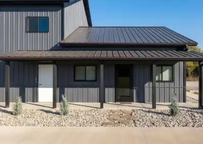 Modern steel pole barn with timber post detail and metal roofing.