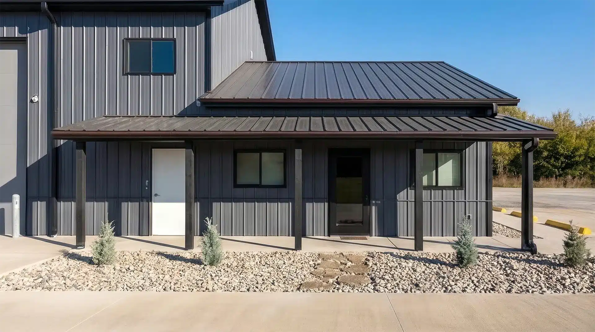 Modern steel pole barn with timber post detail and metal roofing.
