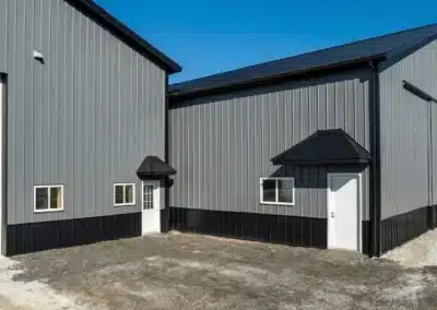 Modern residential pole barn garage with black wainscoting and steel construction
