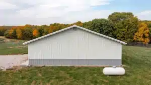 Rear view of a 60x42 steel barn in Kingston, Ontario with autumn trees.