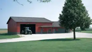 Side elevation of a red 60x66 steel barn with a tractor in Waterloo, Ontario.
