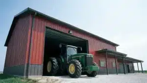 Steel farm shop with machinery bay in Waterloo, featuring a green tractor.