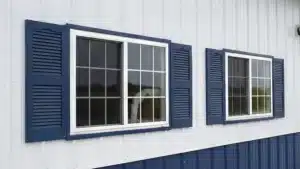 Detail of metal building office windows with blue shutters in Brampton, Ontario.